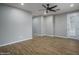 Bright living room features wood floors, neutral walls, ceiling fan, and natural light at 9041 W Redbird Rd, Peoria, AZ 85383