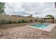 Backyard swimming pool with water feature, decorative wall, and desert landscaping at 9041 W Redbird Rd, Peoria, AZ 85383