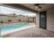 Covered patio overlooks beautiful pool with water feature and fire pit, creating an inviting outdoor oasis at 9041 W Redbird Rd, Peoria, AZ 85383