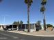 Charming mobile home featuring a covered parking area and mature palm trees at 9501 E Broadway Rd # 21, Mesa, AZ 85208