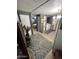 Hallway featuring grey walls and flooring, as well as the laundry area and a bedroom at 9501 E Broadway Rd # 21, Mesa, AZ 85208