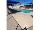 A pool with blue water and tables with chairs in a sunny outdoor space with palm trees at 9501 E Broadway Rd # 21, Mesa, AZ 85208