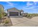 Well-maintained home with desert landscaping, spacious driveway, and a two-car garage at 10004 S Smythe Dr, Apache Junction, AZ 85120