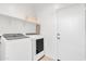 Bright laundry room with newer front loading machines, utility sink, and a storage shelf at 10004 S Smythe Dr, Apache Junction, AZ 85120