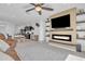 Open-concept living room featuring a modern fireplace, ceiling fan, and neutral decor at 10004 S Smythe Dr, Apache Junction, AZ 85120