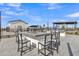 An outdoor kitchen and dining area features a grilling space, firepit, and ample seating at 10004 S Smythe Dr, Apache Junction, AZ 85120