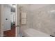 Clean bathroom boasting a white bathtub with marbled tile surround and towel rack at 1226 E Greenway Cir, Mesa, AZ 85203