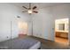 Primary bedroom featuring neutral carpet, a ceiling fan, and ensuite bathroom with natural light at 1226 E Greenway Cir, Mesa, AZ 85203