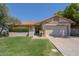 Charming home featuring a well-manicured lawn, desert landscaping, and a two-car garage at 1226 E Greenway Cir, Mesa, AZ 85203