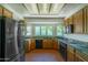 Well-lit kitchen boasts granite counters, wood cabinets, black appliances, and a bay window at 1226 E Greenway Cir, Mesa, AZ 85203
