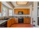 Classic kitchen featuring wood cabinets, granite countertops, and terracotta tile flooring at 1226 E Greenway Cir, Mesa, AZ 85203