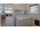 Convenient laundry room featuring modern appliances and storage shelf at 1226 E Greenway Cir, Mesa, AZ 85203