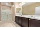 Bathroom with double sinks, dark cabinets, and a walk-in shower at 1367 S Country Club Dr # 1299, Mesa, AZ 85210