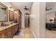 Bathroom featuring stone shower, double sinks, wooden cabinetry, and tile flooring at 1508 N Alta Mesa Dr # 120, Mesa, AZ 85205