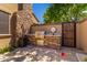 Outdoor kitchen with built-in grill, stone facade, and outdoor dining, all within a walled patio at 1508 N Alta Mesa Dr # 120, Mesa, AZ 85205