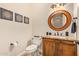 A powder room features a decorative mirror, custom vanity, granite countertop, and framed wall art at 1508 N Alta Mesa Dr # 120, Mesa, AZ 85205