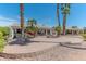 Backyard with desert landscaping, palm trees, and a patio area with seating at 15371 W Piccadilly Rd, Goodyear, AZ 85395