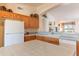 Bright kitchen featuring tile countertops, wood cabinetry, and modern white appliances at 15371 W Piccadilly Rd, Goodyear, AZ 85395