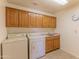 Laundry room with washer, dryer, utility sink, and ample cabinet space at 15371 W Piccadilly Rd, Goodyear, AZ 85395