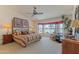 Spacious main bedroom with a bay window, ceiling fan, and a king-sized bed at 15371 W Piccadilly Rd, Goodyear, AZ 85395