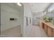 Spacious bathroom featuring a walk-in closet, glass shower, and vanity with granite countertops at 16313 W Escondido Ct, Surprise, AZ 85374