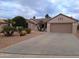 Charming single-story home with a well-maintained yard, complemented by a spacious driveway leading to a two-car garage at 16313 W Escondido Ct, Surprise, AZ 85374