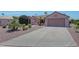 Charming single-story home with desert landscaping, mature palms, and a spacious concrete driveway at 16313 W Escondido Ct, Surprise, AZ 85374