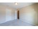 Empty bedroom with light walls, carpet, ceiling light, and white doors to the closet and bathroom at 1652 E Judi St, Casa Grande, AZ 85122