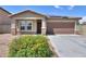 Charming single-Gathering home featuring a tile roof, two-car garage, desert landscaping, and a cozy front porch at 1652 E Judi St, Casa Grande, AZ 85122