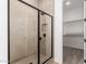 Luxurious walk-in shower with tiled walls and modern black hardware, attached to a well-organized closet at 18174 W Ashley Dr, Goodyear, AZ 85338