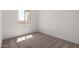 Bright bedroom with a window showing exterior light and neutral carpet at 18174 W Ashley Dr, Goodyear, AZ 85338
