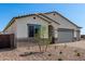 Home exterior with desert landscaping and three car garage at 18174 W Ashley Dr, Goodyear, AZ 85338