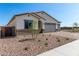 Charming single-story home showcasing a neutral stucco exterior, three-car garage, and low maintenance desert landscaping at 18174 W Ashley Dr, Goodyear, AZ 85338