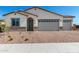 Charming single-story home with desert landscaping, brick driveway, and a two-car garage at 18174 W Ashley Dr, Goodyear, AZ 85338