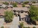 An aerial view of a home featuring a well-manicured front yard, a long driveway, and a tile roof at 18390 W Hayden Dr, Surprise, AZ 85374