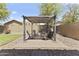 Backyard with stone patio, a small pergola with seating, and a grill at 18390 W Hayden Dr, Surprise, AZ 85374