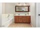 Bathroom featuring a bathtub, a double-sink vanity with wooden drawers, and tile floors at 18390 W Hayden Dr, Surprise, AZ 85374