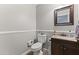 Cozy bathroom featuring a toilet, vanity with sink, framed mirror, and decorative elements at 18390 W Hayden Dr, Surprise, AZ 85374