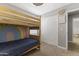 Neutral bedroom with a bunk bed, closet and cute decorations including a hand-painted rainbow on the wall at 18390 W Hayden Dr, Surprise, AZ 85374