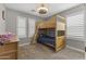 Cozy ' bedroom with carpet floors, a wood bunk bed and plenty of natural light from the shuttered windows at 18390 W Hayden Dr, Surprise, AZ 85374