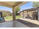 Covered patio with stone flooring, a small pergola, a grill and a lush green backyard at 18390 W Hayden Dr, Surprise, AZ 85374