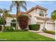 Stucco two-story home with tile roof, lush landscaping and paved walkway at 2026 E Cortez Dr, Gilbert, AZ 85234