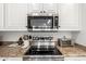 Modern kitchen features stainless steel appliances and granite countertops, with white cabinets at 2026 E Cortez Dr, Gilbert, AZ 85234