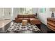 Cozy living room features a brown leather sofa and a patterned rug on hardwood floor at 2026 E Cortez Dr, Gilbert, AZ 85234