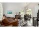 Open-concept living room with hardwood floors, a leather sectional couch, and a dining area with lots of natural light at 2026 E Cortez Dr, Gilbert, AZ 85234