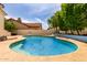 Inviting backyard oasis with a sparkling blue pool, tanning deck and mature trees offering shade at 2026 E Cortez Dr, Gilbert, AZ 85234
