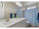 Bathroom featuring a dual sink vanity, a large mirror, and a shower with blue patterned curtains at 22925 N 46Th St, Phoenix, AZ 85050