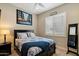 Bedroom with a black-frame bed, blue and white bedding, and shuttered windows at 22925 N 46Th St, Phoenix, AZ 85050