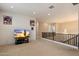 Open bonus room with shiplap accent wall, carpet, and an elegant light fixture by the stair railing at 22925 N 46Th St, Phoenix, AZ 85050