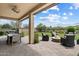 Elegant covered patio with a dining area, outdoor grill, and inviting seating around a stone fire pit at 22925 N 46Th St, Phoenix, AZ 85050